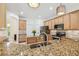 Kitchen featuring a stainless steel sink, granite countertops, wooden cabinets, and modern lighting fixtures at 10080 Cove Lake Dr, Orlando, FL 32836