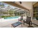 Covered patio area offers seating and views of the screened-in pool at 10080 Cove Lake Dr, Orlando, FL 32836