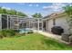 Backyard showcasing a screened-in pool, patio, and well-maintained lawn at 10080 Cove Lake Dr, Orlando, FL 32836