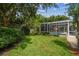 Lush backyard featuring a screened-in pool, mature trees, and green lawn at 10080 Cove Lake Dr, Orlando, FL 32836
