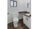 Toilet and vanity with dark countertop and white cabinets in neutral bathroom at 101 Grand Plaza Dr # A40, Orange City, FL 32763