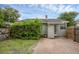 Backyard with brick patio, lush greenery, and manicured hedges for privacy at 1021 N Forest Ave, Orlando, FL 32803