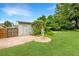 Lush backyard features verdant lawn, brick patio, storage shed, and garden statue at 1021 N Forest Ave, Orlando, FL 32803