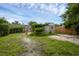 Expansive backyard with brick-paved patio, decorative statue, garage and lush greenery at 1021 N Forest Ave, Orlando, FL 32803