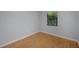 Simple bedroom with hardwood floors and one window providing natural light at 1021 N Forest Ave, Orlando, FL 32803