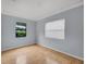 Bright bedroom features wood floors, neutral walls, and two large windows at 1021 N Forest Ave, Orlando, FL 32803