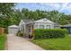Charming single-story home featuring a well-manicured lawn, a detached garage, and a welcoming red front door at 1021 N Forest Ave, Orlando, FL 32803