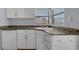 Functional kitchen featuring granite countertops, white cabinets, and stainless steel faucet at 1021 N Forest Ave, Orlando, FL 32803