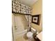 This bathroom features a shower and tub combination with patterned shower curtain and artwork at 10350 Lake District Ln # S, Orlando, FL 32832