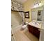 This bathroom features a shower and tub combination with patterned shower curtain and artwork at 10350 Lake District Ln # S, Orlando, FL 32832