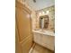 Half bathroom featuring elegant wallpaper and a marble vanity with framed mirror at 10350 Lake District Ln # S, Orlando, FL 32832