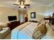 This bedroom features a ceiling fan and king bed with bedside seating and dresser at 10350 Lake District Ln # S, Orlando, FL 32832