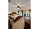 Bright bedroom boasts a ceiling fan, a king bed, French doors, and relaxing armchair at 10350 Lake District Ln # S, Orlando, FL 32832