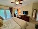 Bright bedroom boasts a ceiling fan, a king bed, dresser, and relaxing armchair at 10350 Lake District Ln # S, Orlando, FL 32832