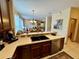 Open-concept kitchen with countertops, stainless steel dishwasher, and breakfast bar overlooking the living area at 10350 Lake District Ln # S, Orlando, FL 32832