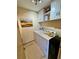 Functional laundry room featuring a washer, dryer, overhead cabinets, and charming wall art at 10350 Lake District Ln # S, Orlando, FL 32832