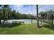 Community pickleball courts are surrounded by a fence and are set among mature trees and next to a green lawn at 10350 Lake District Ln # S, Orlando, FL 32832