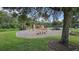 Neighborhood playground with slides, climbing structures and swings is surrounded by trees and a mulch base at 10350 Lake District Ln # S, Orlando, FL 32832