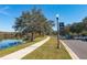 Scenic street view alongside a lake, featuring a walking path and a welcoming community sign at 10350 Lake District Ln # S, Orlando, FL 32832