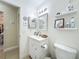Bright bathroom with white vanity, framed mirror, and decorative shelves, all in a tidy space at 10460 Riva Ridge Trl, Orlando, FL 32817