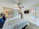 Bedroom featuring tile flooring, ceiling fan, a door to backyard, and a mounted television at 10460 Riva Ridge Trl, Orlando, FL 32817
