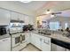 Kitchen with stainless steel appliances, white cabinets, granite counters and views to living area at 10460 Riva Ridge Trl, Orlando, FL 32817