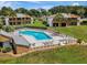 Aerial view showcases a community pool surrounded by condos, green space, and mature trees at 1051 S Highland St # 5E, Mount Dora, FL 32757