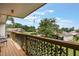 Relaxing balcony with a wooden railing and a view of lush greenery and neighborhood homes at 1051 S Highland St # 5E, Mount Dora, FL 32757