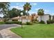 Condo exterior with tan and white stucco, lush landscaping, and tall palm trees at 1051 S Highland St # 5E, Mount Dora, FL 32757