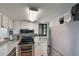 Charming kitchen featuring white cabinets, stainless steel appliances, and granite countertops at 1051 S Highland St # 5E, Mount Dora, FL 32757