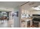 Efficient kitchen featuring white cabinetry, modern appliances, and granite countertops, adjacent to the living area at 1051 S Highland St # 5E, Mount Dora, FL 32757