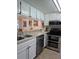 Bright kitchen featuring stainless steel appliances, granite countertops, and white cabinetry at 1051 S Highland St # 5E, Mount Dora, FL 32757