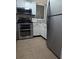 Well-lit kitchen with stainless steel appliances and neutral-toned flooring, with black window shutters at 1051 S Highland St # 5E, Mount Dora, FL 32757