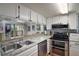 A modern kitchen with white cabinets, granite countertops, and stainless-steel appliances at 1051 S Highland St # 5E, Mount Dora, FL 32757