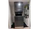 Efficient laundry area with stacked washer and dryer, plus storage and access to HVAC equipment at 1051 S Highland St # 5E, Mount Dora, FL 32757