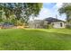 Expansive backyard with a screened-in pool area, lush greenery, and a charming brick wall at 1141 Waldorf Ct, Winter Springs, FL 32708