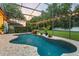 Beautiful pool area with a rock waterfall feature, complemented by lush landscaping and ambient lighting at 1141 Waldorf Ct, Winter Springs, FL 32708