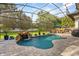 Inviting pool area featuring a rock waterfall, surrounded by lush landscaping and comfortable lounge seating at 1141 Waldorf Ct, Winter Springs, FL 32708