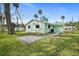 Charming backyard with paver patio, lush green grass, and tropical palm tree accents at 124 Oak Ridge Ave, Edgewater, FL 32132