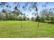 Large fenced backyard with mature trees and green grass at 124 Oak Ridge Ave, Edgewater, FL 32132