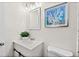 Well-lit bathroom with a modern vanity, mirror, and stylish coastal-themed artwork at 124 Oak Ridge Ave, Edgewater, FL 32132
