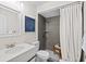 Clean bathroom with gray tile shower, modern vanity, and a coastal-themed art piece at 124 Oak Ridge Ave, Edgewater, FL 32132