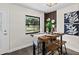 Dining area with wood table, decor, and a window view of the yard. Adjacent to rear entry door at 124 Oak Ridge Ave, Edgewater, FL 32132