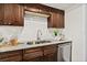 Close-up of kitchen sink, countertops, and dark wood cabinets with stainless steel dishwasher at 124 Oak Ridge Ave, Edgewater, FL 32132