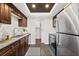 Bright kitchen includes stainless steel appliances and dark wood cabinets adjacent to the laundry room at 124 Oak Ridge Ave, Edgewater, FL 32132