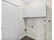 Laundry room with white cabinets, neutral paint, and updated flooring at 124 Oak Ridge Ave, Edgewater, FL 32132