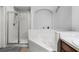 Bright bathroom featuring a glass-enclosed shower, soaking tub, and white tile surround at 13826 Mirror Lake Dr, Orlando, FL 32828