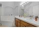 Bathroom featuring a dual sink vanity, soaking tub, updated light fixture and neutral countertops at 13826 Mirror Lake Dr, Orlando, FL 32828