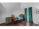 Bright bedroom with hardwood floors, a comfortable bed with unique bedding, and a window with green curtains at 13826 Mirror Lake Dr, Orlando, FL 32828