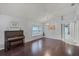 Open living area with polished wood floors, piano, and a bay window seat at 13826 Mirror Lake Dr, Orlando, FL 32828